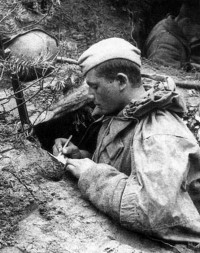Западный фронт, 1941. Советский солдат в окопе пишет письмо.