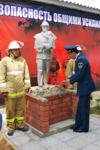 Гости и жители села возложили живые цветы к фигуре пожарного со спасенным ребенком на руках. Фото cap.ru